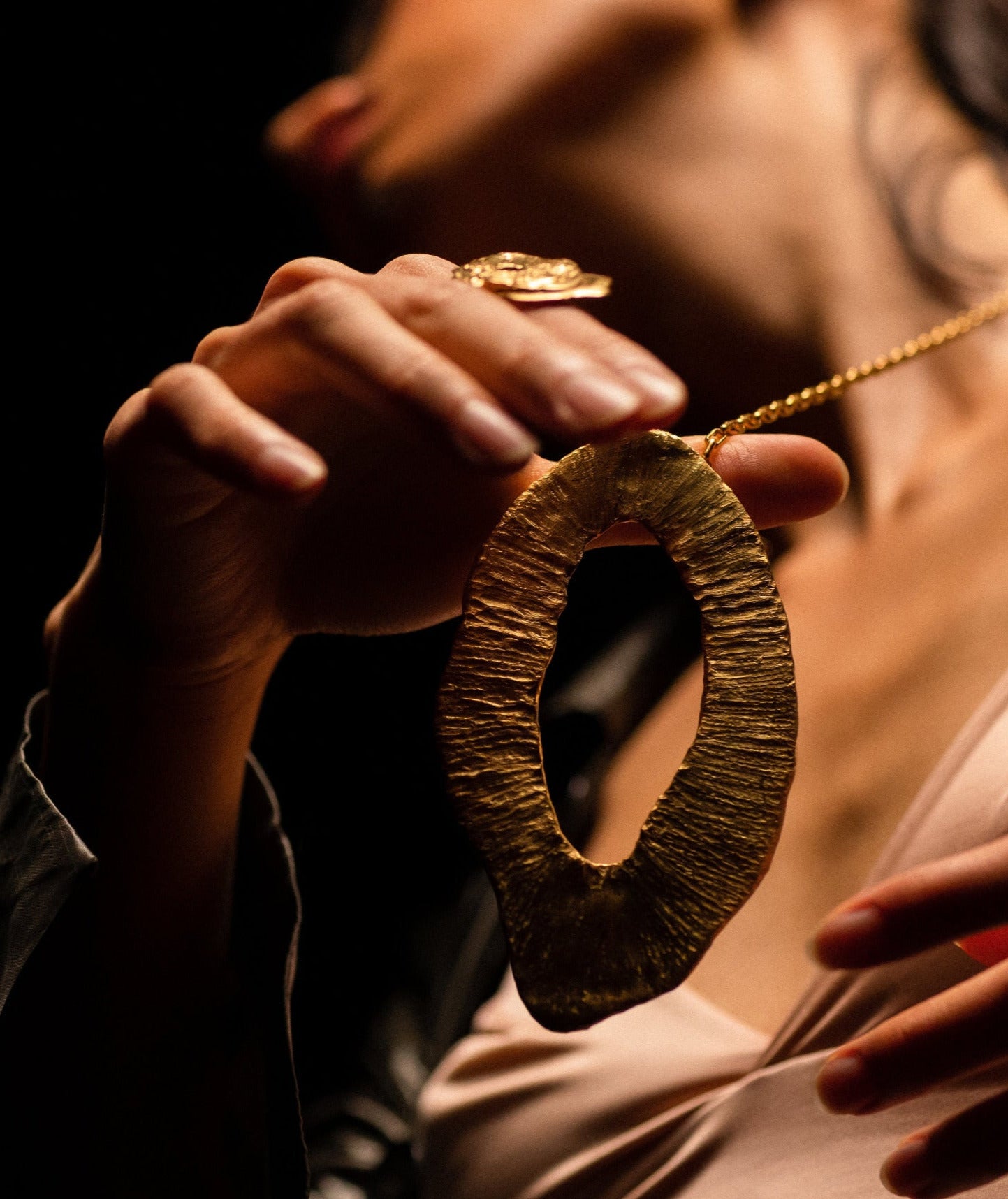 brass necklace worn, it is golden, oval and very textured